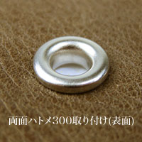両面ハトメ300を厚み1.5mmの革にとりつけたとき表面。2.5mm幅の縁をもったドーナッツ状の金属の輪のように仕上がります